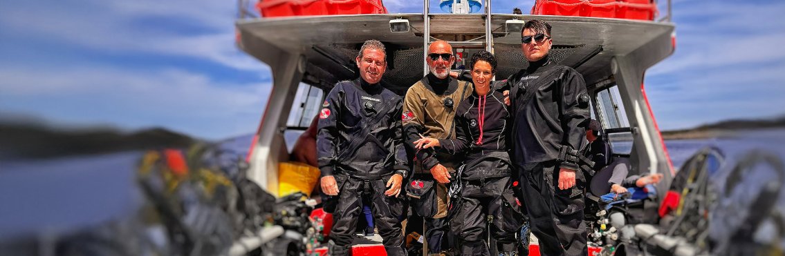 Subacquei con mute DiveSystem sulla barca di un diving center